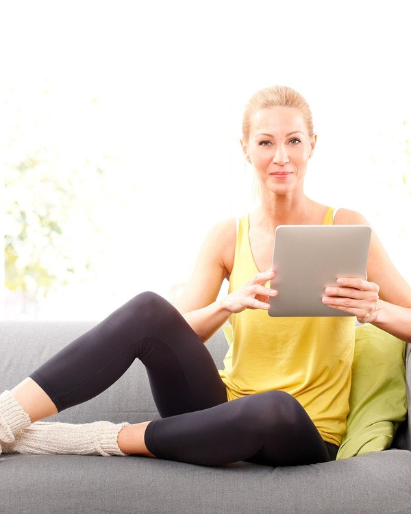 Woman over 40 working out at home with dumbbells and resistance band